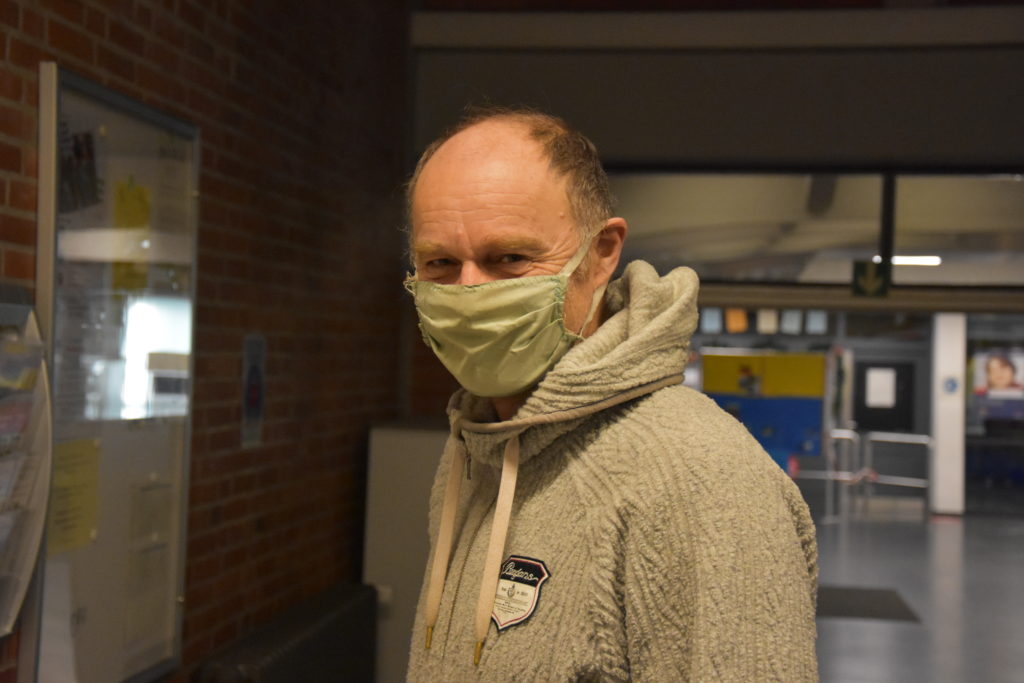 Kollege mit Mund-Nasen-Maske im Flur.