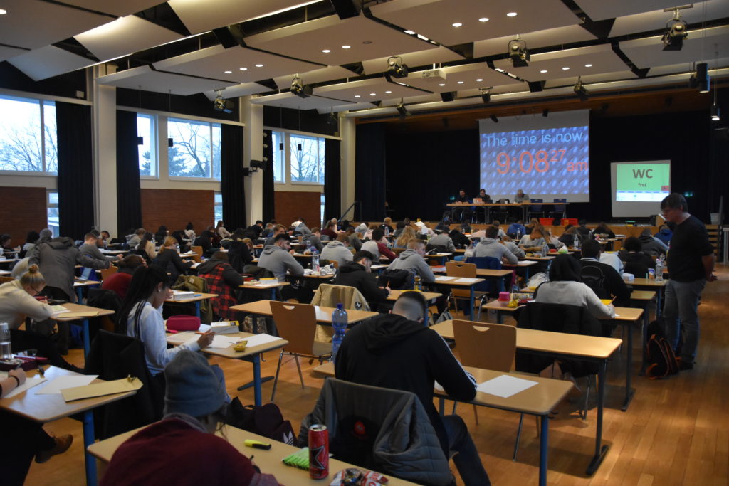 Schriftliche Abiturprüfung in einem großen Saal.