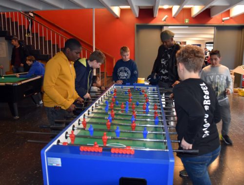 Schüler spielen Kicker im Pausencafé.