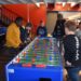 Schüler spielen Kicker im Pausencafé.