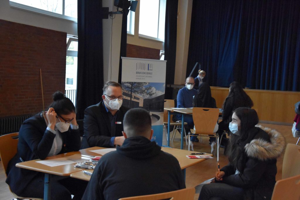 Schülerinnen und Schüler an einem Beratungstisch bei der Berufsmesse.