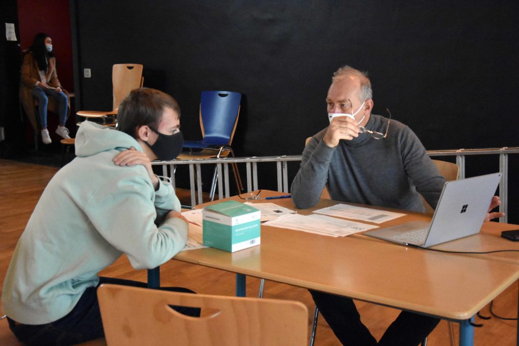 Beratungsgespräch zwischen einem Schüler und einem Aussteller bei der Berufsmesse.