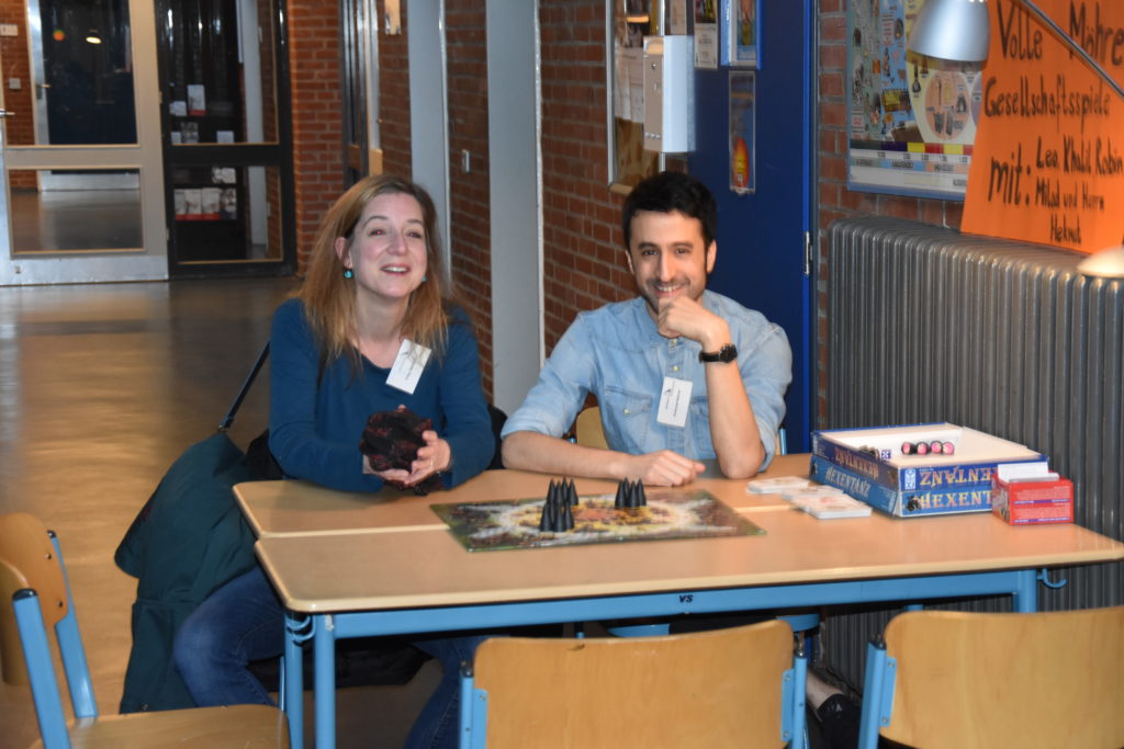 Zwei Lehrkräfte sitzen an einem Tisch im Klassenraum.