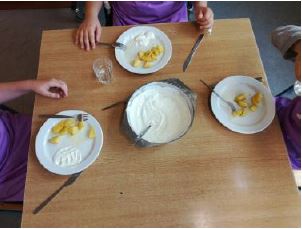 Teller mit Obst und Joghurt auf dem Tisch der Lehrküche.