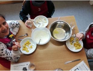 Kinder probieren in der Lehrküche selbst zubereitete Speisen.