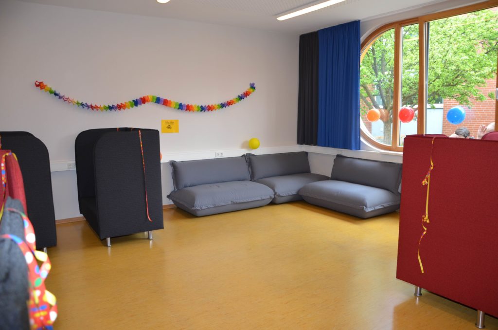 Gemütlicher Aufenthaltsraum mit Sofas, Lichterkette und Wimpeln.