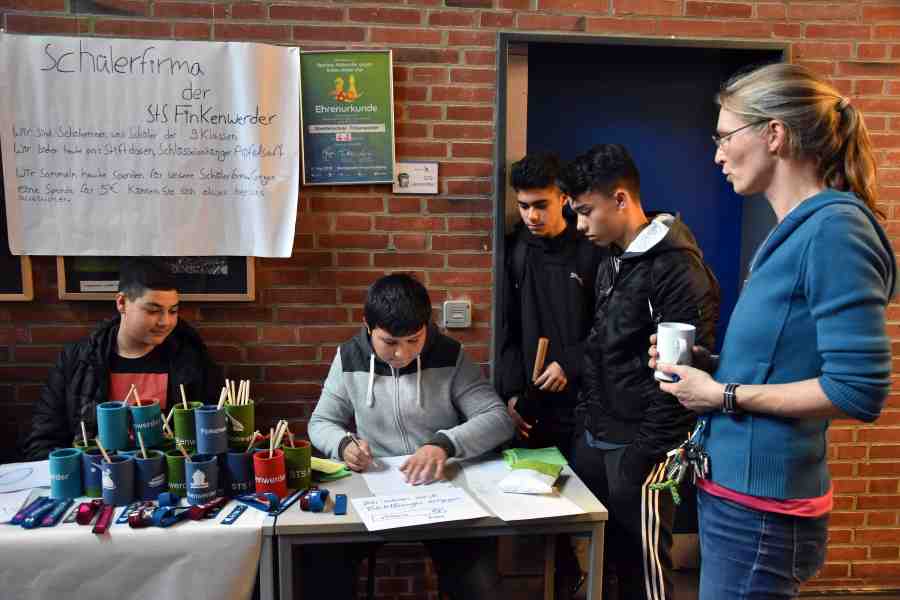 Verkaufsstand der Schülerfirma mit Schülern und einer Lehrerin.