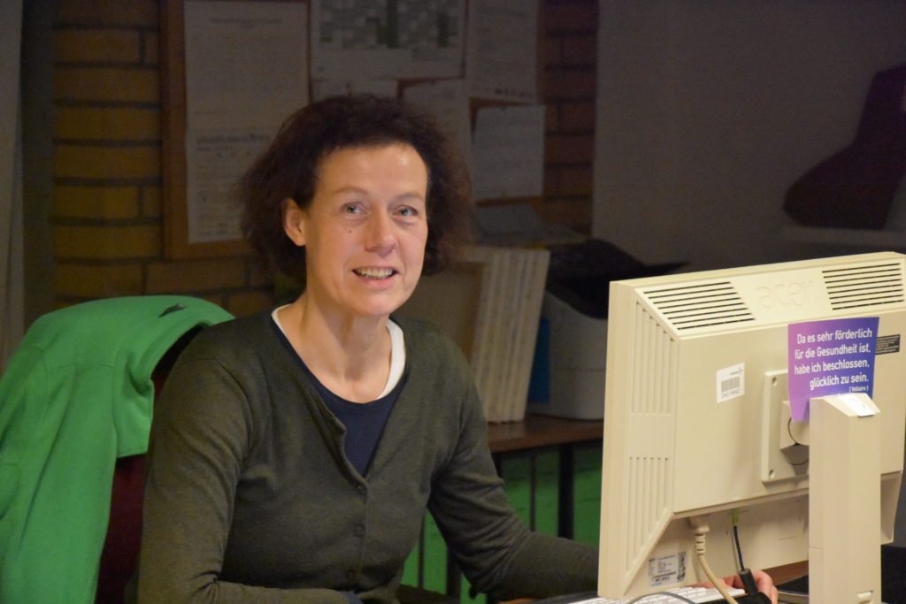 Mitarbeiterin an einem Schreibtisch mit Computer.