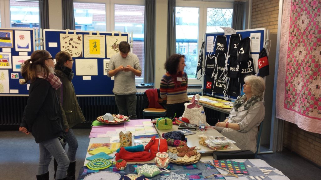 Ausstellung von Kursarbeiten, Besucherinnen und Besucher schauen sich um.