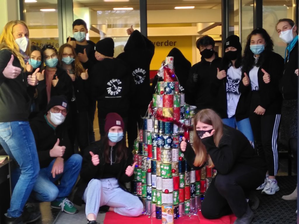 Gruppe der Prefects vor dem Baum aus gespendeten Konservendosen.