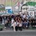 Gruppenfoto der Austauschgruppe vor einer bemalten Mauer in Palästina.