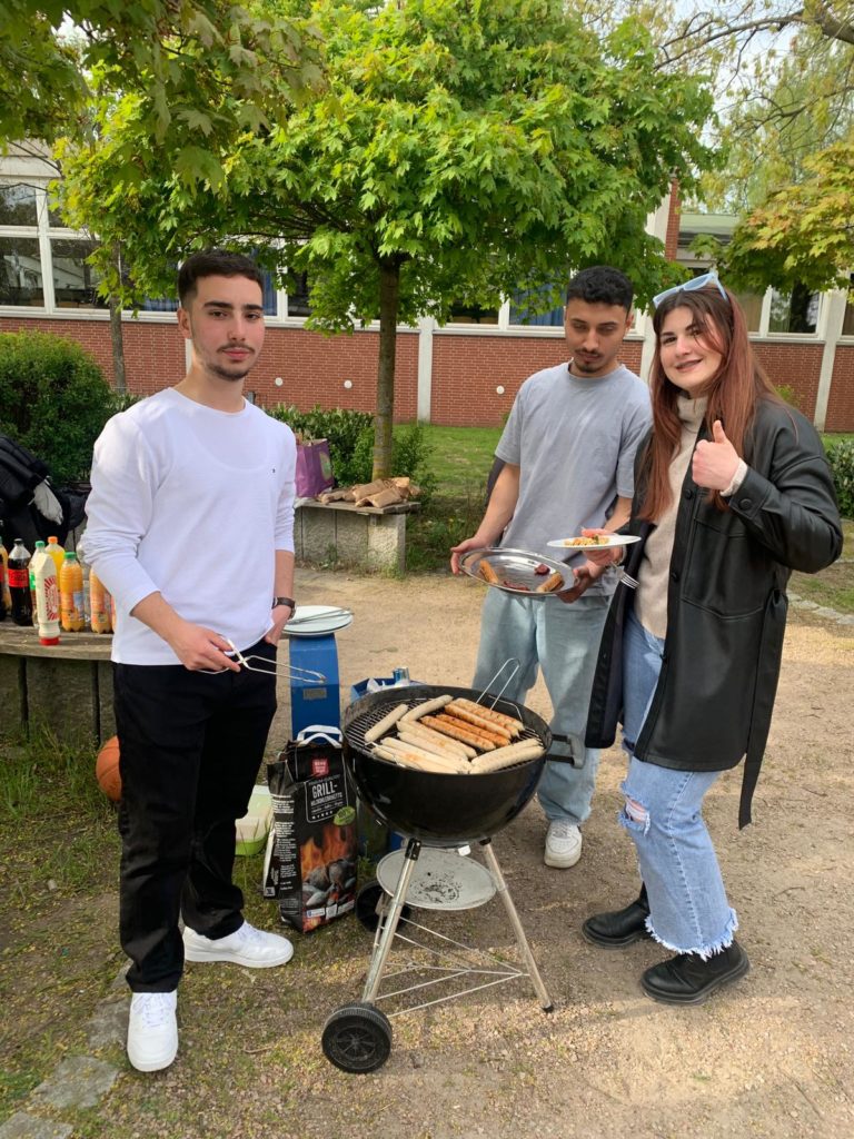 Schüler grillen beim Abschiedsgrillen auf dem Schulgelände.
