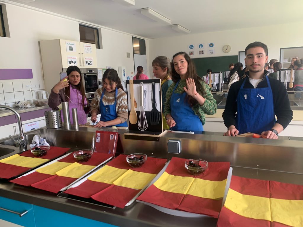 Tapas-Buffet in der Pausenhalle, dekoriert mit spanischen Flaggen.