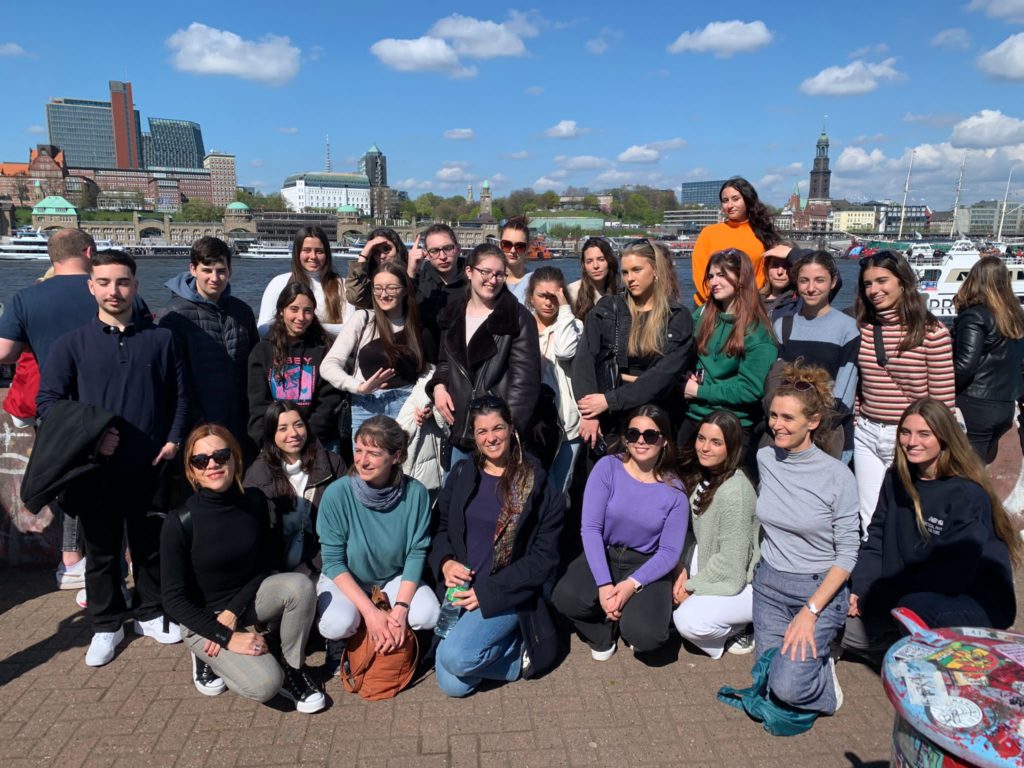 Gruppenfoto der Austauschgruppe am Hafen, im Hintergrund der Michel.