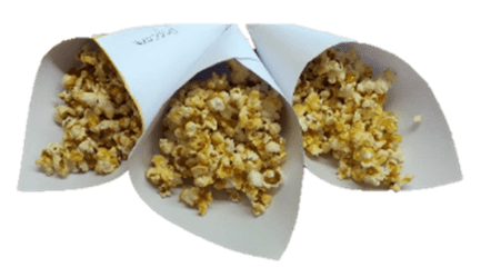 Drei Papiertüten mit Popcorn.