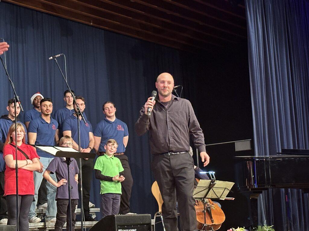 Chor und Dirigent beim Weihnachtskonzert in der Aula.