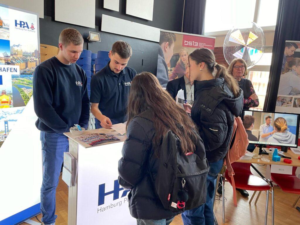 Jugendliche informieren sich an einem Messestand.