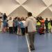 Viele Schülerinnen und Schüler stehen in einer langen Reihe in der Sporthalle.