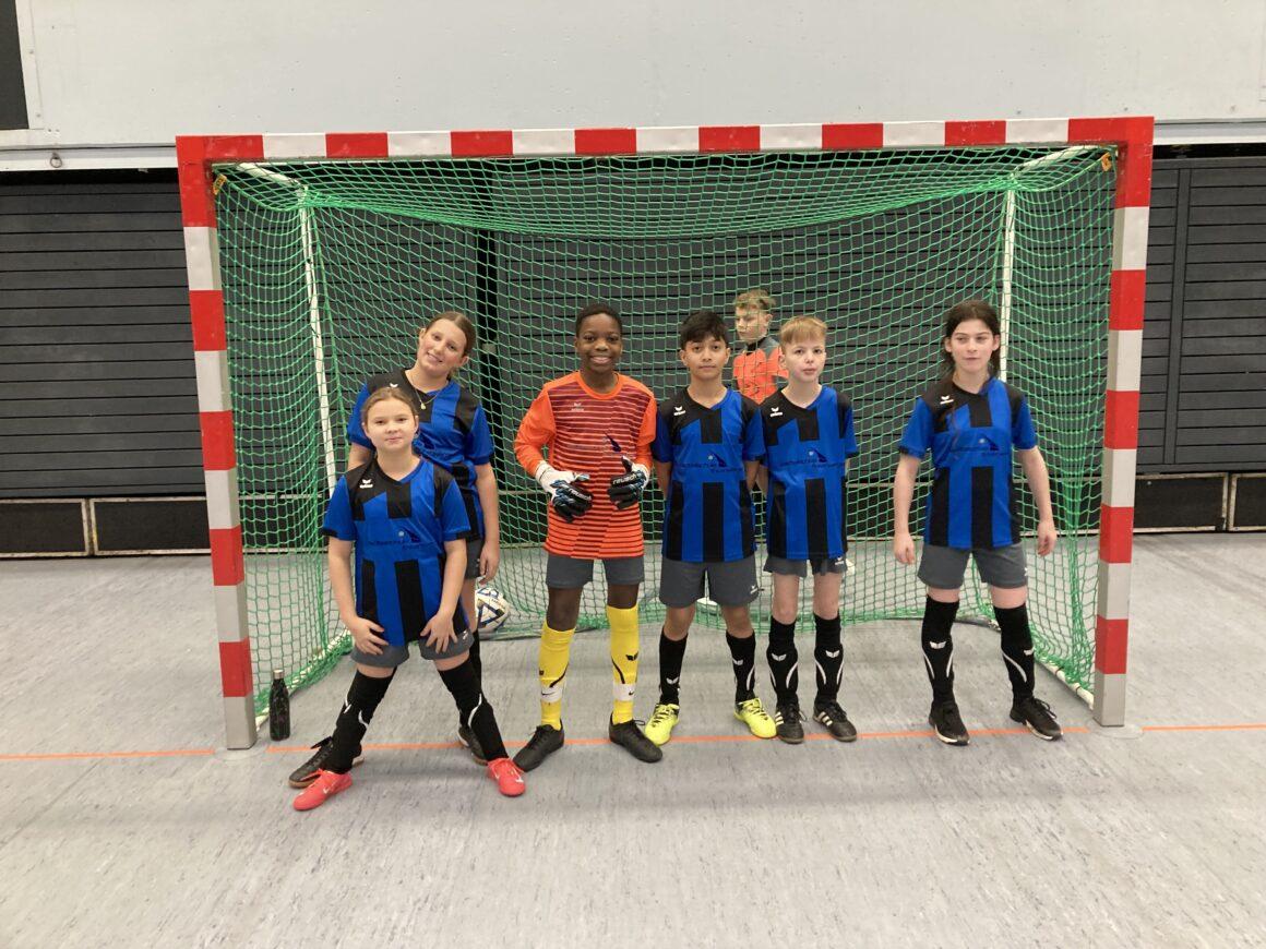 Futsal-Mannschaft der Schule vor einem Tor.
