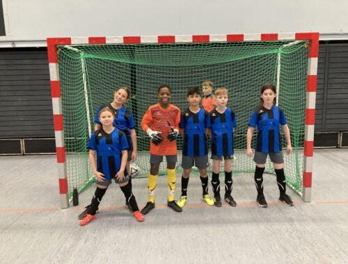 Futsal-Mannschaft der Schule vor einem Tor.