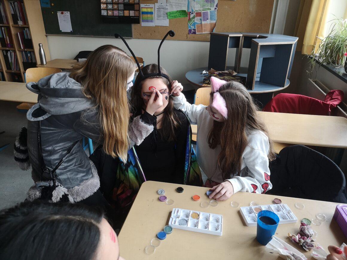 Schülerinnen schminken sich gegenseitig im Kurs.