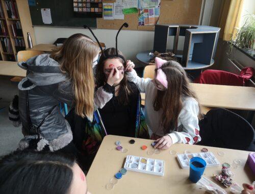 Schülerinnen schminken sich gegenseitig im Kurs.