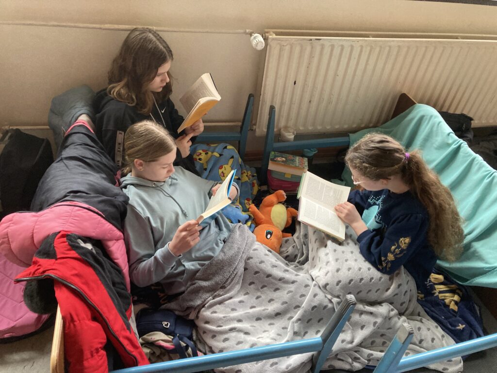 Kinder lesen gemütlich auf Kissen und Decken.