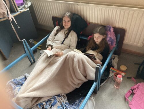 Schülerinnen lesen eingekuschelt in Decken.