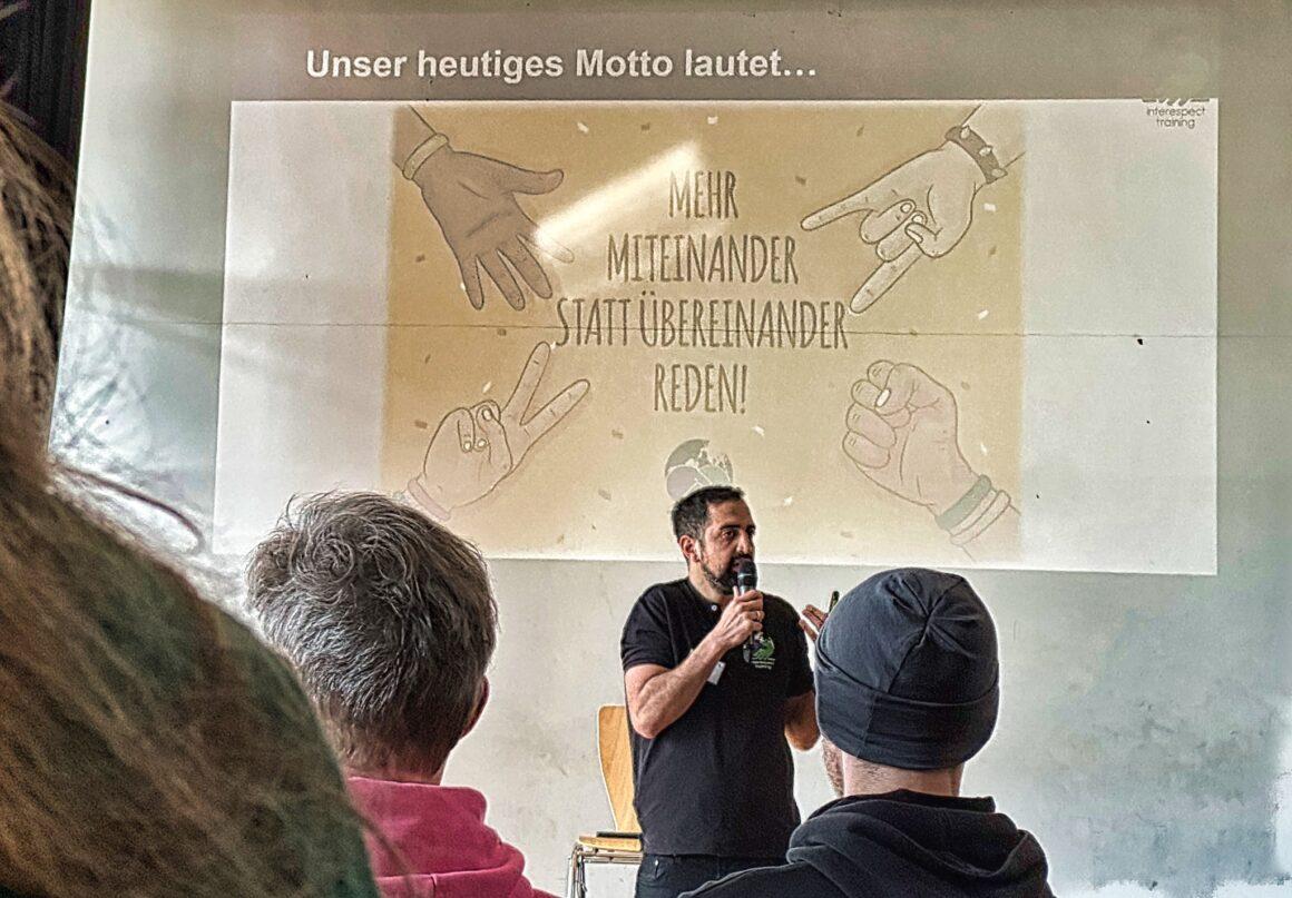 Referent spricht beim Fachtag vor einer Präsentation zum Thema diversitätssensible Schule.