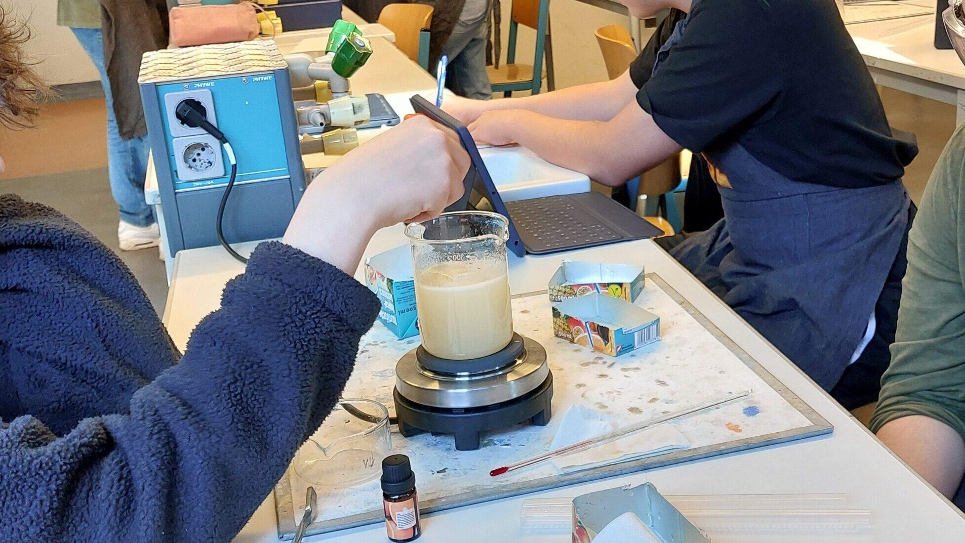 Schülerinnen und Schüler stellen im Unterricht Seife her.