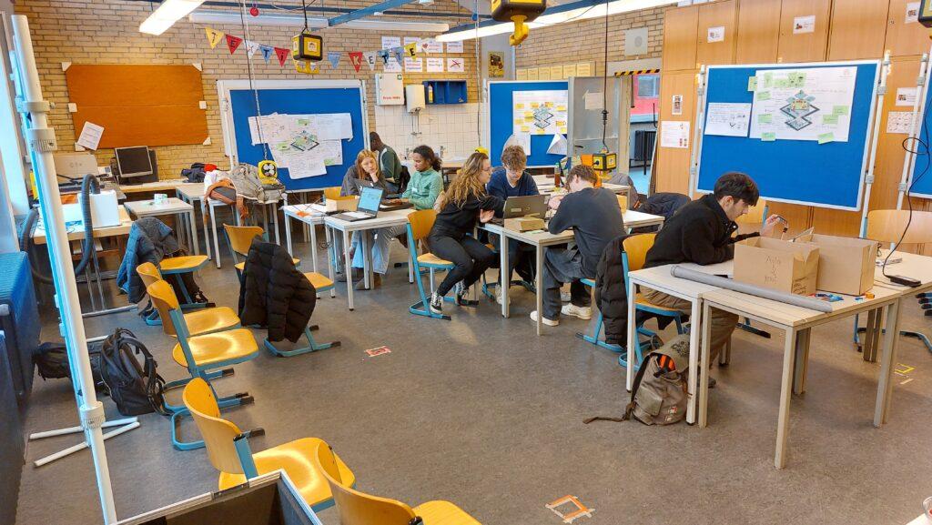 Teams arbeiten bei den Hackdays an Tischen in der Mensa.