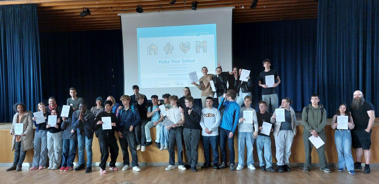 Gruppenfoto der Teilnehmenden der Hackdays auf der Bühne.