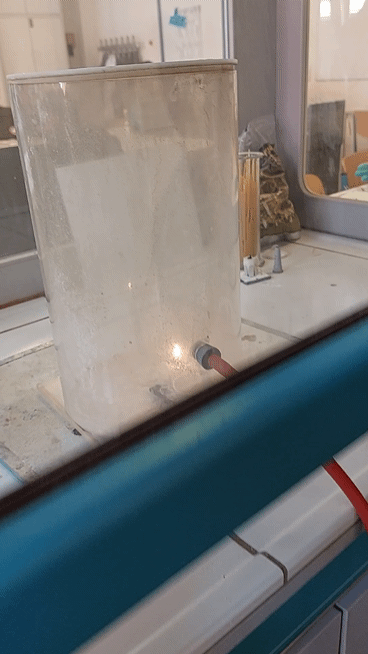 Flamme in einem Glaszylinder bei einem Experiment.