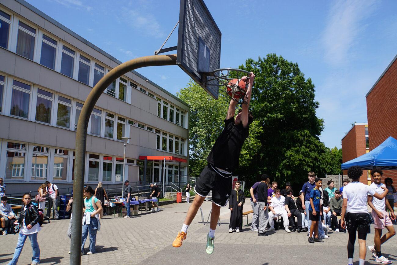 Streetball-Turnier auf dem Schulhof: ein Spieler wirft auf den Korb.
