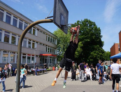 Streetball-Turnier auf dem Schulhof: ein Spieler wirft auf den Korb.