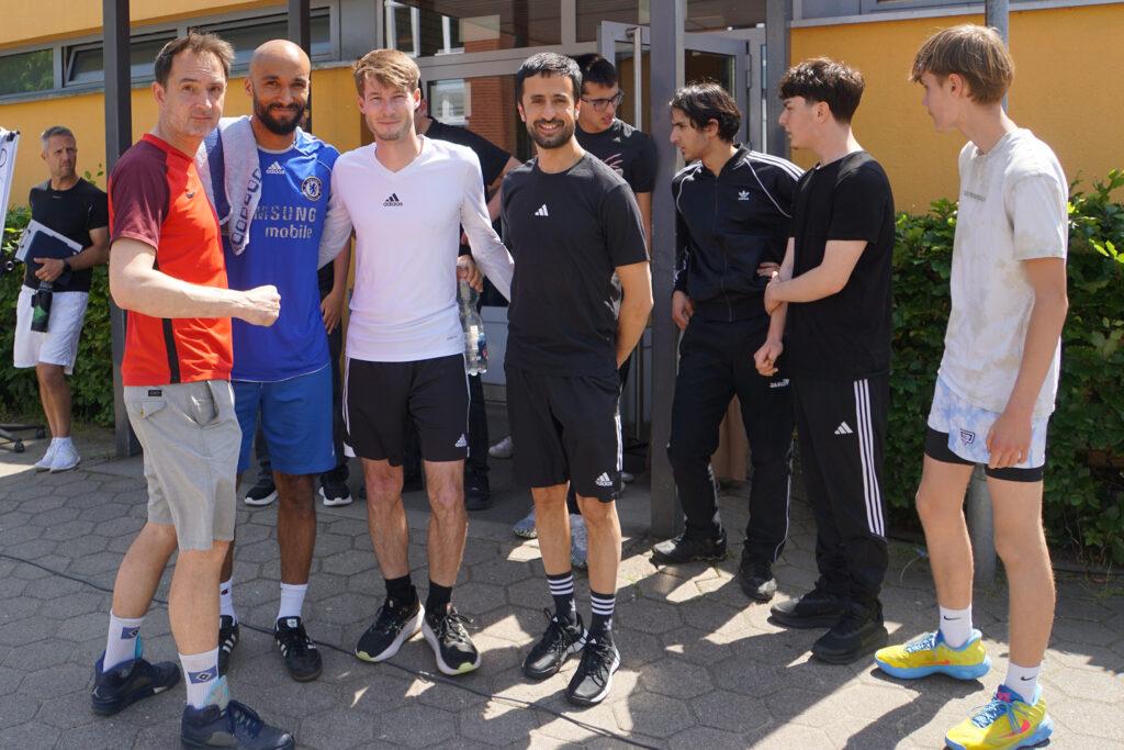 Lehrkräfteteam des Streetball-Turniers posiert auf dem Schulhof.