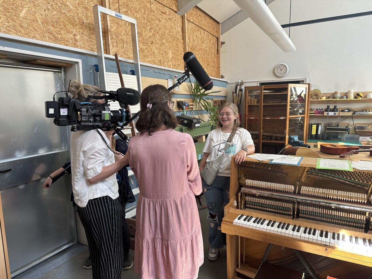 Ein Fernsehteam filmt das Klavier in der Werkstatt.