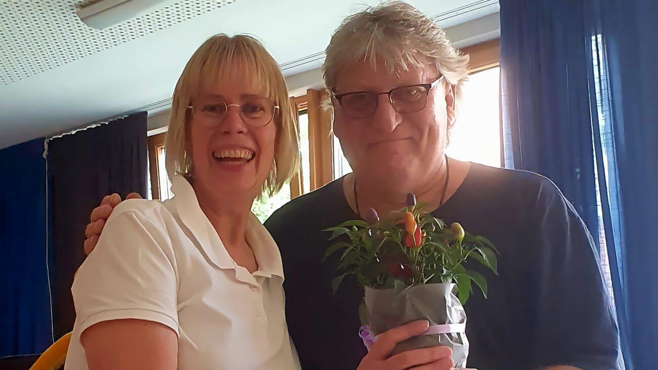 Zwei Frauen vom Schulverein bei der Verabschiedung, eine hält eine Pflanze.