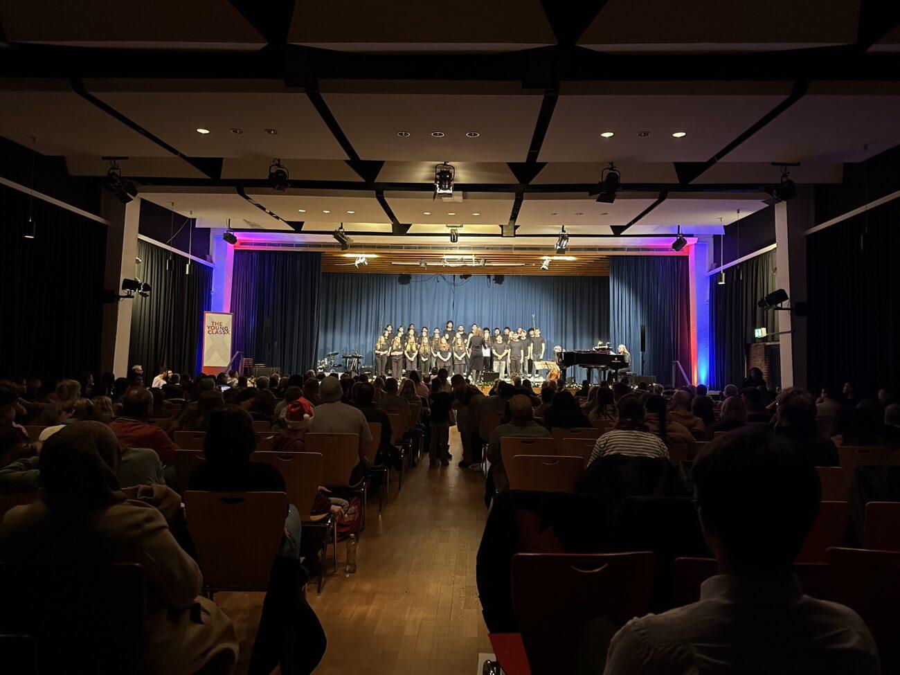 Konzert in der vollen, abgedunkelten Aula.