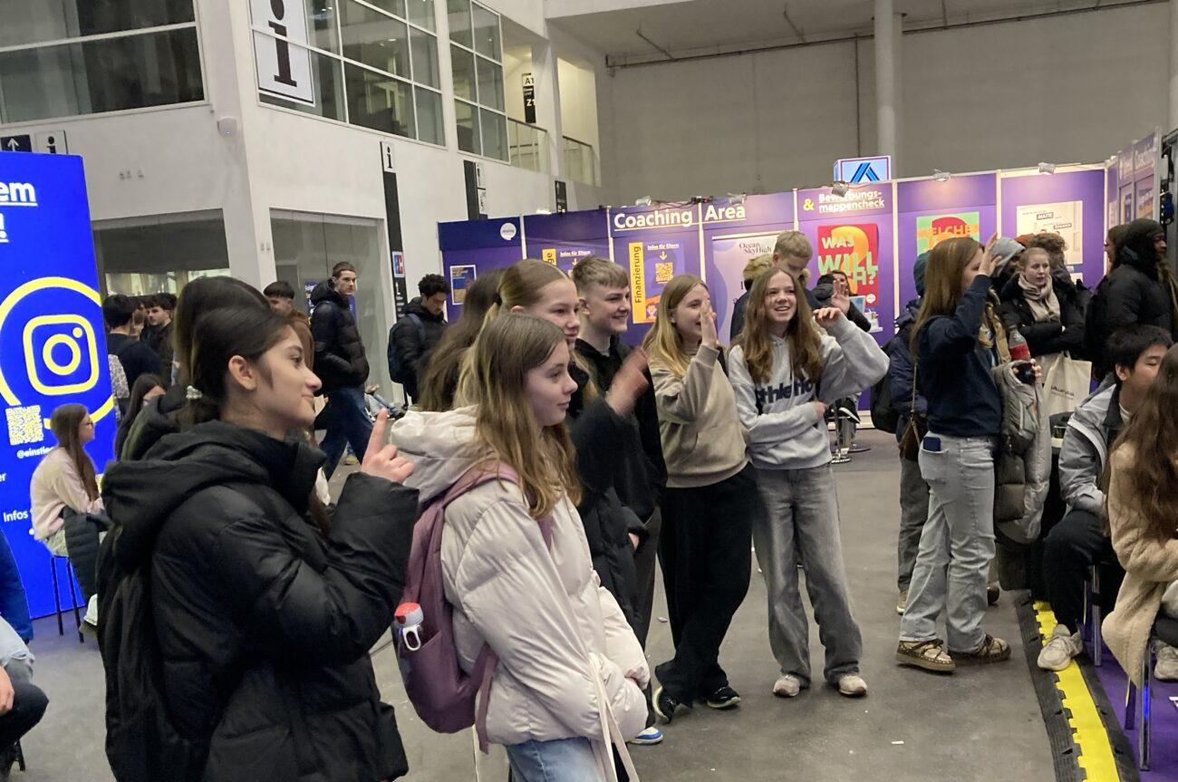 Schülerinnen und Schüler bei einer Veranstaltung mit Infoständen.