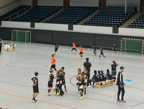 Basketballspiel 3 gegen 3 in einer Sporthalle.