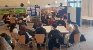 Informationsveranstaltung im Worldcafé-Format: Gruppen sitzen an Tischen in der Mensa.