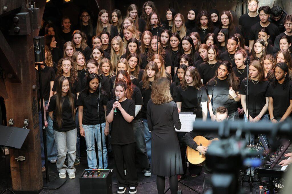 Großer Chor in schwarzen T-Shirts auf der Bühne.