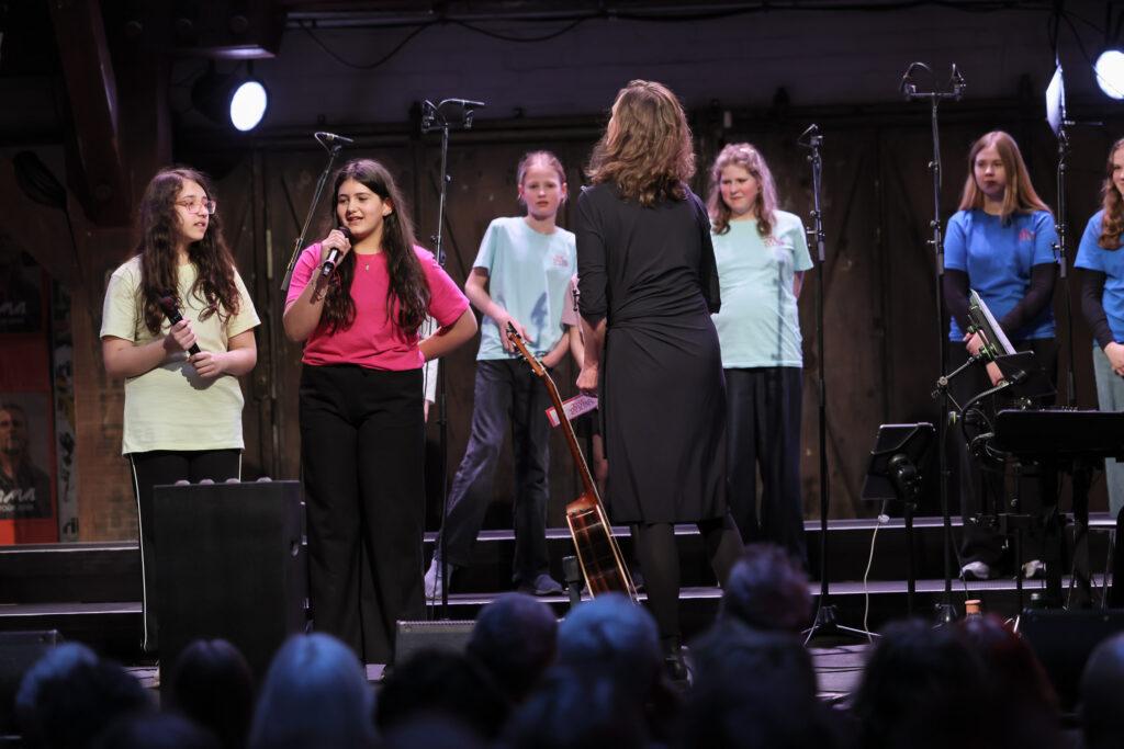 Mehrere Sängerinnen am Mikrofon beim Stadtteilkonzert.