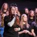 Sängerin am Mikrofon vor dem Chor beim Stadtteilkonzert.