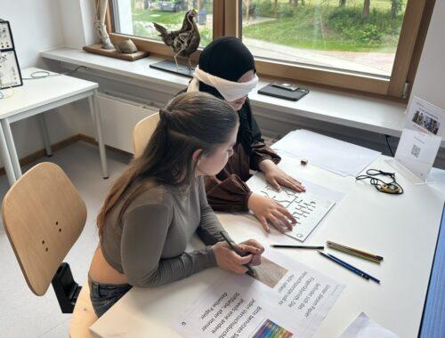 Schülerin mit Augenbinde bei einem Experiment im Biologiekurs.
